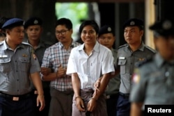 FILE - Police escort detained Reuters journalists Kyaw Soe Oo and Wa Lone as they arrive before a court hearing in Yangon, Myanmar, Aug. 20, 2018.