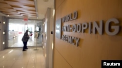 FILE - A woman walks into the head office for the World Anti-Doping Agency (WADA) in Montreal, Nov. 9, 2015. 