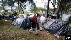 Para migran Venezuela kemping di sebuah taman dekat terminal bus di Bogota, Kolombia, 7 September 2018.