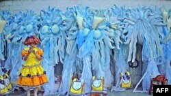 A performer waits in front of carnival costumes on the second night of Rio's Carnival at the Sambadrome in Rio de Janeiro, Brazil, on February 12, 2018.