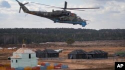 Helikopter militer Angkatan Darat Belarusia terbang di atas lapangan selama latihan militer Union Courage-2022 Russia-Belarus di tempat latihan Obuz-Lesnovsky di Belarus, Sabtu, 19 Februari 2022. (Foto: AP)