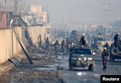 Afghan security forces inspect the site of a car bomb blast in Kabul, Jan. 15, 2018.