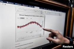Petugas Badan Meteorologi, Klimatologi dan Geofisika (BMKG) sedang memperhatikan grafik peningkatan gelombang pasang menyusul tsunami yang menerjang Selat Sunda di Pelabuhan merak, Banten, 24 Desember 2018. (Foto: Antara Foto/Muhammad Adimaja/ via Reuters)