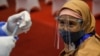 Seorang perempuan bersiap menerima suntikan vaksin Sinovac selama program vaksinasi massal di Bursa Efek Indonesia di Jakarta. (Foto: REUTERS/Willy Kur
