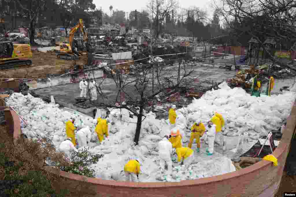 A drone view shows workers in protective suits collecting burnt asbestos from the Eaton fire at a destroyed school, Loma Alta Elementary School in Altadena, California, Feb. 5, 2025.