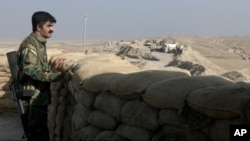 A militiaman from the Kurdistan Freedom Party, an Iranian Kurdish opposition group, stands behind his truck-mounted machine gun on a section of the frontline near the Iraqi city of Kirkuk on Sept. 5, 2016.