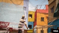 A man prepares another wall for painting in the art-lined neighbourhood that has been named Ouzville. (J. Owens for VOA)