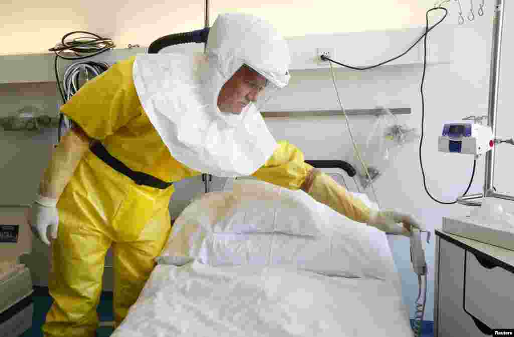 Infection control nurse Heinz Schuhmacher wears a protective suit during a media presentation at an isolation ward for possible Ebola patients at the Universitaetsspital Basel hospital in Basel, Switzerland, Oct. 15, 2014.