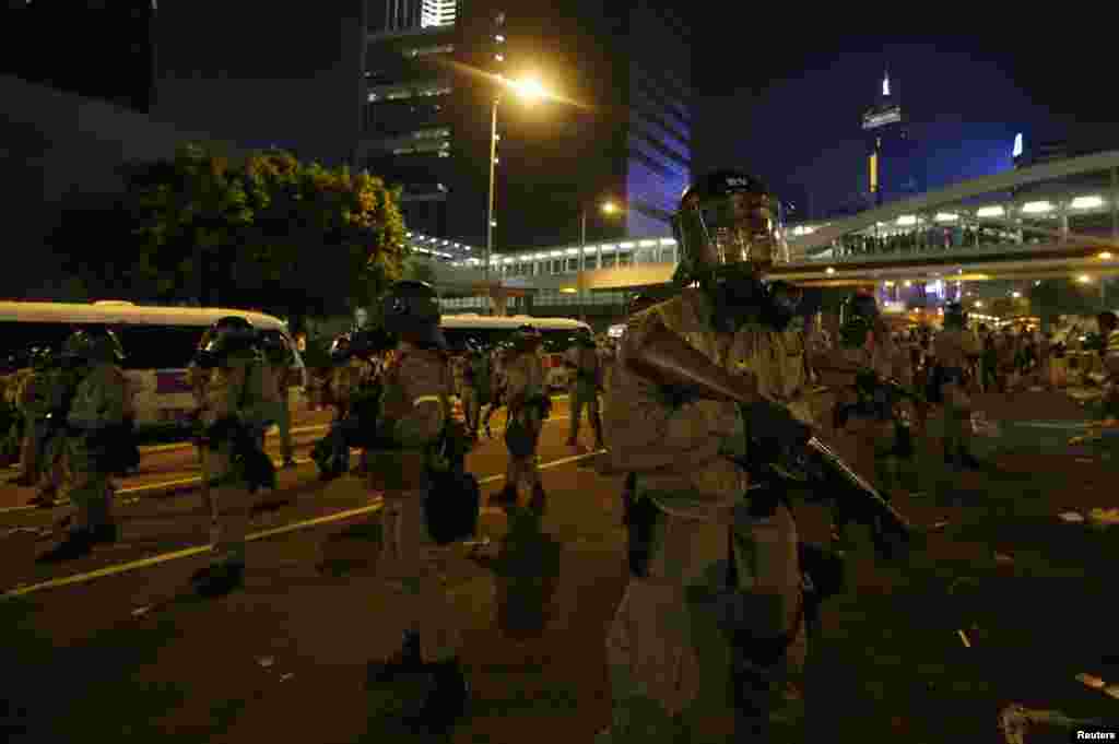 香港防爆警察手持催泪弹发射器与抗议者对峙。抗议者堵住了通往港府外面的金融中心区的主要道路。(2014年9月28日)