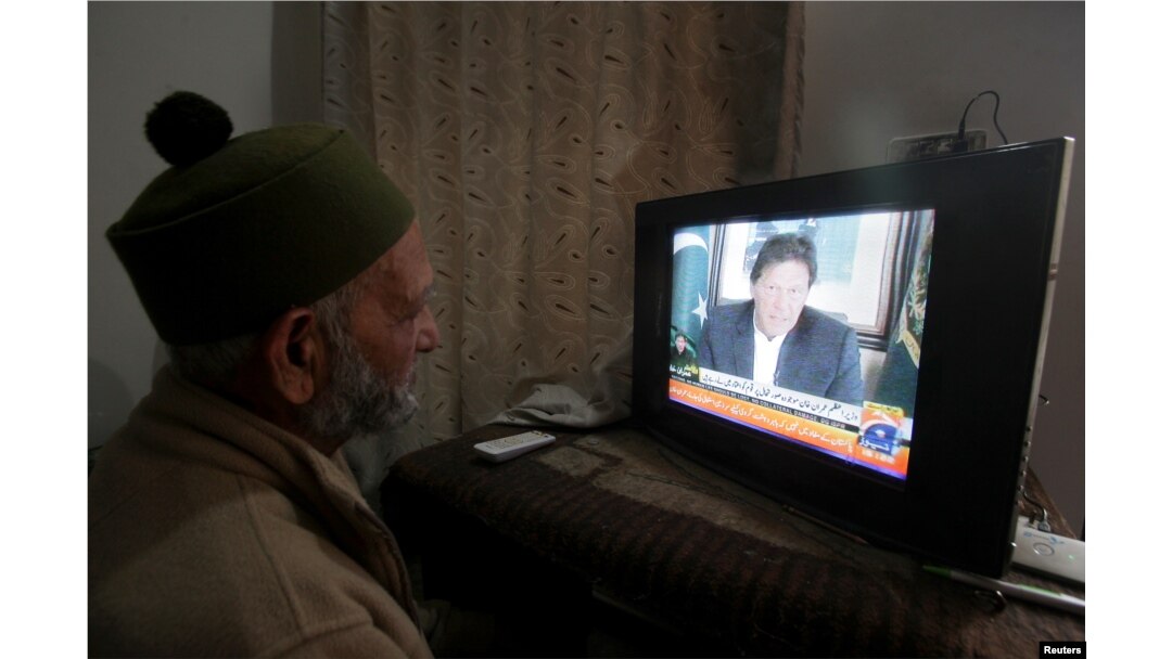 A man watches the speech of the Pakistani Prime Minister Imran Khan, after Pakistan shot down two Indian planes, in Lahore, Pakistan, Feb. 27, 2019.