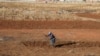 Seorang perempuan berladang di tengah pembatasan wilayah untuk meredam pandemi virus corona (Covid-19), di Soweto, Afrika Selatan, 31 Juli 2020. (Foto: Reuters)