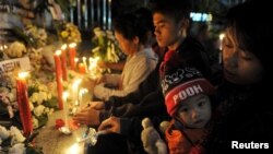 Keluarga korban bom Bali 2002 menyalakan lilin untuk memperingati 13 tahun pemboman di Kuta, Bali, 12 Oktober 2015.