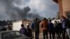 Warga Palestina melihat ke arah kepulan asap pasca serangan udara Israel di kota Khan Younis, Jalur Gaza selatan. 