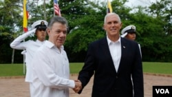 Vice President Mike Pence is welcomed by Colombia's President Juan Manuel Santos, left, in Cartagena, Colombia, Sunday, Aug. 13, 2017.