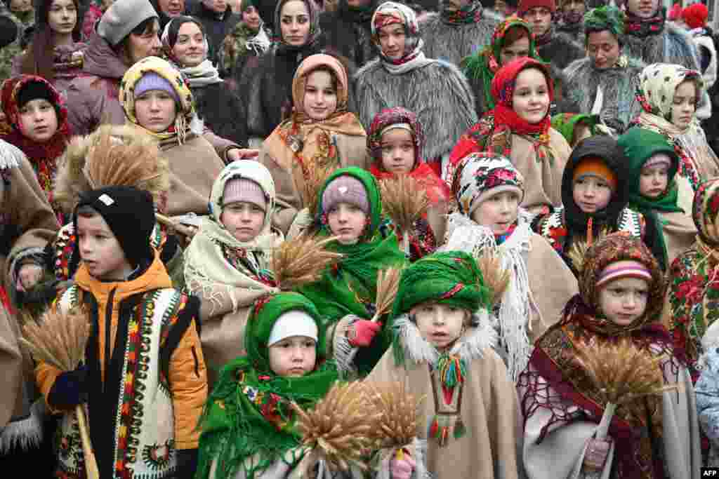 Children wearing traditional clothes carry 'didukh' as they take part in a Christmas Eve procession in Lviv amid the Russian invasion of Ukraine. 'Didukh' is a Ukrainian Christmas decoration made of bunches of wheat, symbolizing sacrifice and literally meaning 'spirit of grandfather.'
