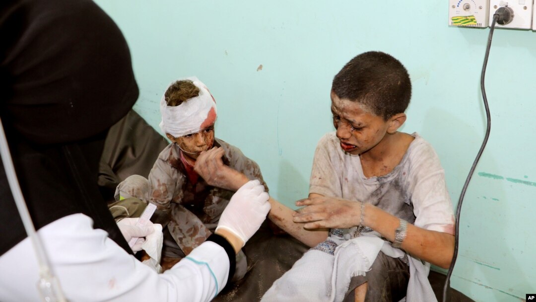 A doctor treats children injured by an airstrike in Saada, Yemen Aug. 9, 2018.