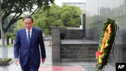 Japanese Prime Minister Yoshihide Suga leaves after laying a wreath at the mausoleum of Vietnam's late President Ho Chi Minh in Hanoi, Vietnam, Oct. 19, 2020.