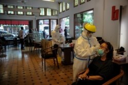 Petugas kesehatan mengambil sampel antigen cepat dari pengunjung di tengah pandemi COVID-19 di Bandung, Jawa Barat, 30 Desember 2020. (Foto: Antara/Raisan Al Farisi via REUTERS)
