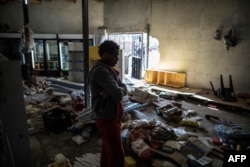 An Ethiopian owner of a looted grocery store stands in his ransacked shop, in Soweto, Johannesburg, South Africa, Aug. 29, 2018.