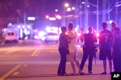 Polisi Orlando mengarahkan keluarga menjauhi lokasi penembakan di sebuah klub malam di Orlando, Florida, 12 Juni 2016.