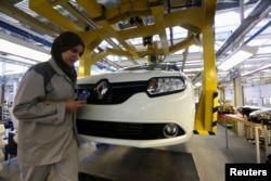 FILE - A female employee works in a Renault factory in Oran, west of Algiers, Nov. 10, 2014.