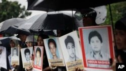 Para kerabat berdemo di luar Kedutaan Besar AS sambil membawa foto para aktivis yang hilang dan korban pelanggaran HAM yang diduga dilakukan oleh sejumlah anggota KOPASSUS pada 1997-1998, 27 Juli 2010. (Foto: Dita Alangkara/AP,arsip)