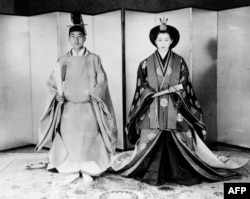Pangeran Akihito (Kiri) dan istrinya Michiko Shoda mengenakan busana pengantin tradisional pada akhir upacara pernikahan di Istana Kekaisaran di Tokyo, 10 April 1959.(Foto: AFP/Arsip)