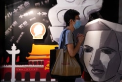 香港支聯會營運的六四紀念館裡一名遊客在一塊刻有民主女神像的板子旁祈禱。