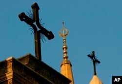 FILE - A minaret of the Mohammed al-Amin Mosque and two crosses on top of the Maronite St. George Cathedral are seen in downtown Beirut, Lebanon, Sept. 17, 2006.