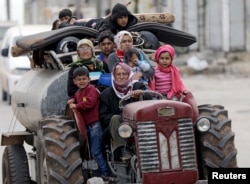 FILE - People flee after Turkish-backed Free Syrian Army fighters captured Khaldieh village in eastern Afrin, Syria, March 10, 2018.