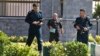FILE - Police officers patrol Iran's parliament building after an assault by several attackers that was claimed by the Islamic State group, in Tehran, Iran, June 7, 2017. Gunmen and suicide bombers attacked Iran’s parliament and the shrine of its revolutionary founder.