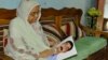 Hajera Khatun, 70, with the photo of her son Sajedul Islam Shumon, who became a victim of enforced disappearance in 2013. (A. Rajjak/VOA)