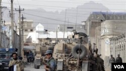 Pasukan Afghanistan dan NATO mengamankan lokasi kantor polisi di Kandahar setelah pemboman yang menewaskan kepala polisi setempat (15/4).