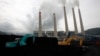 Ekskavator menimbun batu bara di tempat penyimpanan di sebuah pembangkit di Suralaya, Banten, 20 Januari 2010. (Foto: Ilustrasi/Reuters)