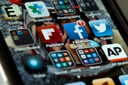 FILE - An iPhone with Twitter, Facebook and other apps, May 21, 2013.