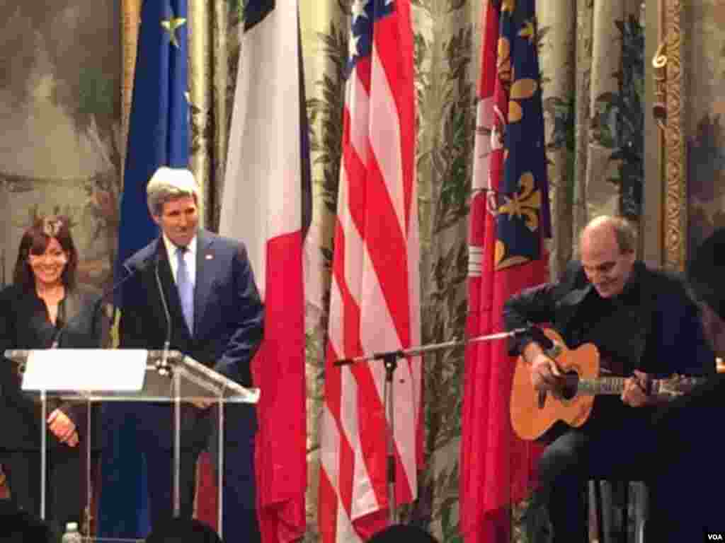Mayor of Paris Anne Hidalgo and U.S. Secretary of State John Kerry listen to a performance by singer James Taylor at City Hall in Paris, Jan. 16, 2015. (Pam Dockins/VOA)