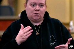 Megan Vozzella, who is deaf, signs while describing concerns following a visit by Steven Dettelbach, director of the ATF, at Central Maine Community College on Feb. 22, 2024, in Auburn, Maine. Vozzella's husband was killed in the October 2023 mass shootings in Lewiston, Maine.
