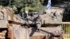 An Israeli army Merkava main battle tank is deployed by the concrete border wall at a position along Israel's northern border with Lebanon, Feb. 18, 2025.