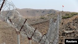 FILE - A view of the border fence outside the Kitton outpost on the border with Afghanistan in North Waziristan, Pakistan, Oct. 18, 2017. 