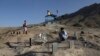 Pria Afghanistan berdoa di dekat makam kerabat mereka yang tewas dalam pemboman di dekat Sekolah Syed Al-Shahada bulan lalu di pemakaman di pinggiran Kabul, Afghanistan, Rabu, 2 Juni 2021. (AP Photo/Rahmat Gul)