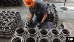中国江苏省连云港，一名工人在工厂里加工传动部件。