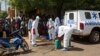 Health workers put on protective gear outside a mosque before disinfecting it, in Bamako, Mali, Nov. 14, 2014.
