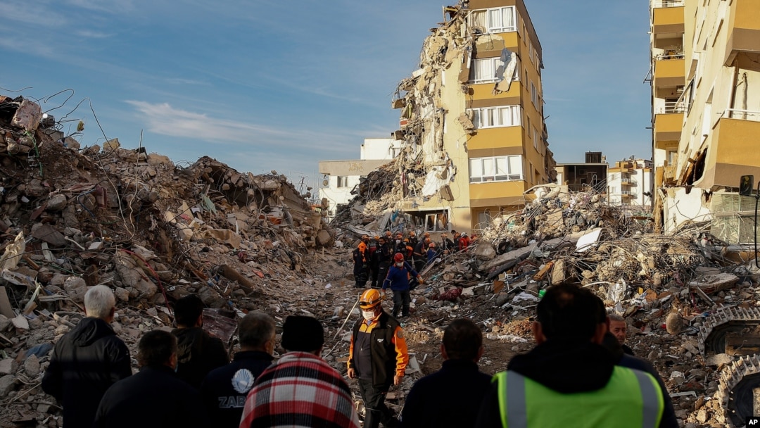 Local residents watch as members of rescue services work at collapsed buildings, destroyed in the Oct. 30 earthquake in Izmir, Turkey, Nov. 3, 2020. 
