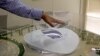 FILE- In this photo taken during a government-organized media tour, an official makes a point using a scale model of the Al-Wakra Stadium, to be used during the 2022 World Cup, in Doha, Qatar, May 4, 2015.