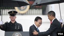 Presiden AS Barack Obama (kanan) menyambut kedatangan Presiden Korea Selatan, Lee Myung-bak di Gedung Putih di tengah hujan lebat (13/10).