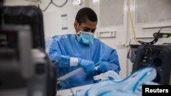 Fredrick Spencer, seorang tentara AS, merakit ventilator T1 Hamilton di unit laboratorium keliling, unit perawatan intensif Javits New York Medical Station yang merawat pasien COVID-19 di Kota New York, 4 April 2020. 