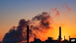 FILE - A coal-fired power plant is silhouetted against the morning sun in Glenrock, Wyoming, July 27, 2018.