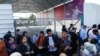 Warga Palestina yang memiliki dwi kewarganegaraan berkumpul di luar penyeberangan perbatasan Rafah dengan Mesir berharap mendapat izin keluar dari Gaza di tengah meningkatnya konflik Israel-Palestina, Sabtu, 14 Oktober 2023. (Foto: Ibraheem Abu Mustafa/Reuters)