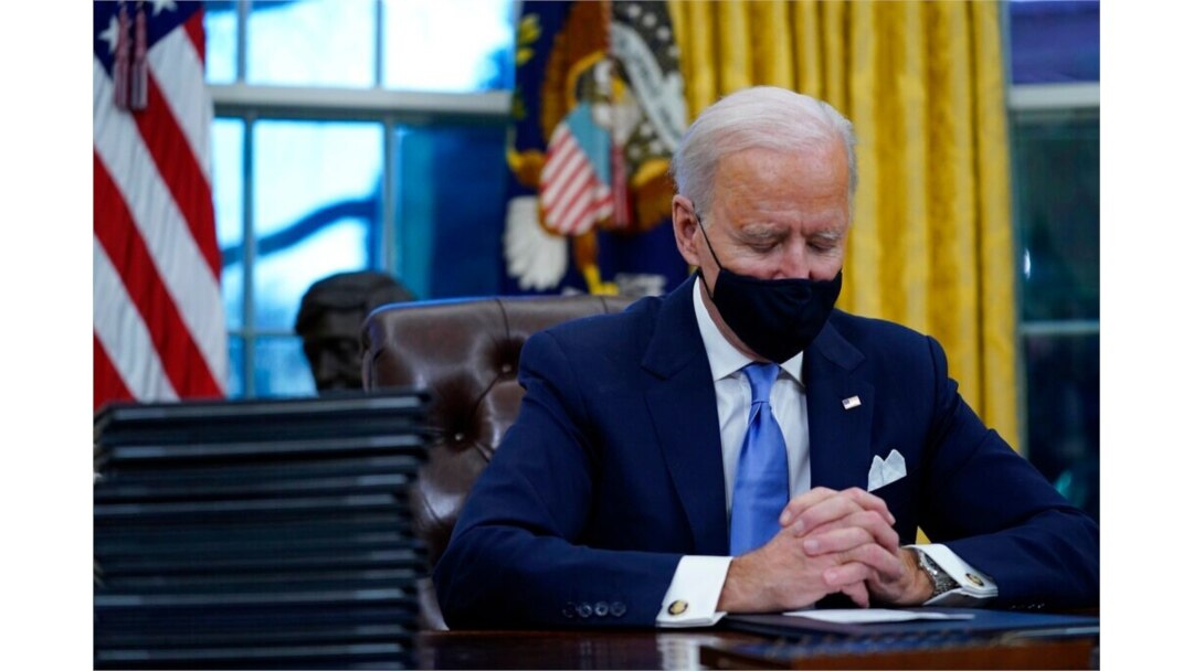 FILE - President Joe Biden pauses as he signs his first executive orders in the Oval Office of the White House, Jan. 20, 2021.