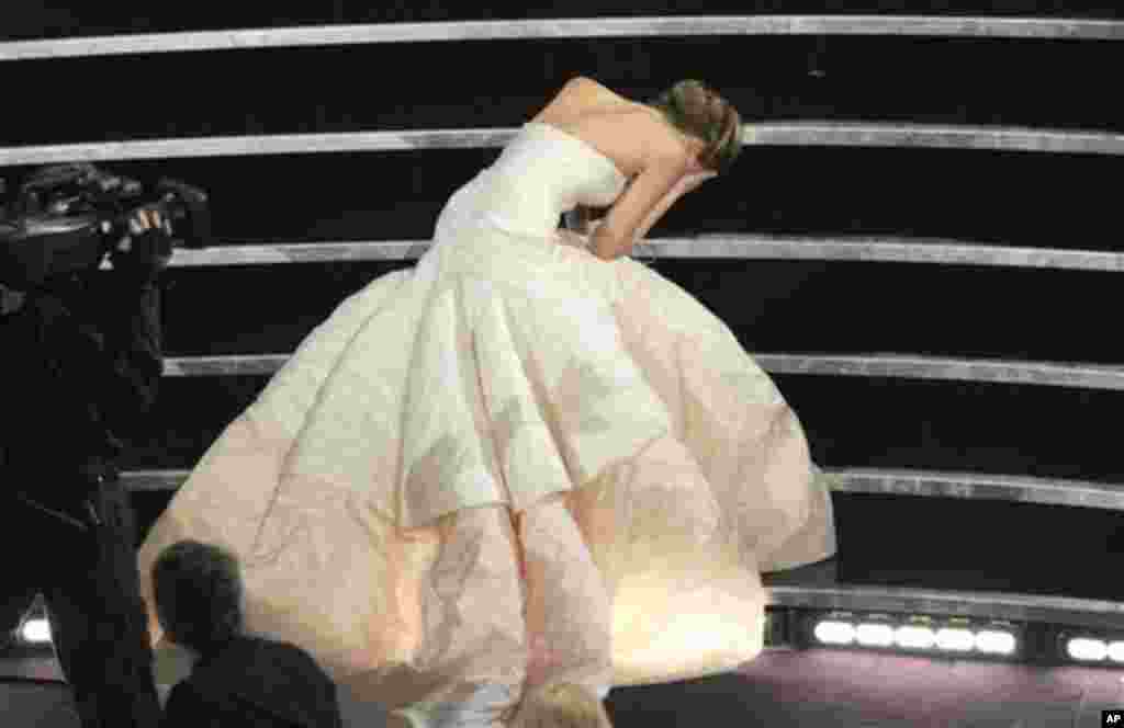 Aktris Jennifer Lawrence tersandung dan jatuh saat berjalan ke panggung untuk menerima penghargaan aktris terbaik untuk film "Silver Linings Playbook" pada Academy Awards ke-85 di Dolby Theatre, Los Angeles (24/2). (AP/Chris Pizzello/Invision)